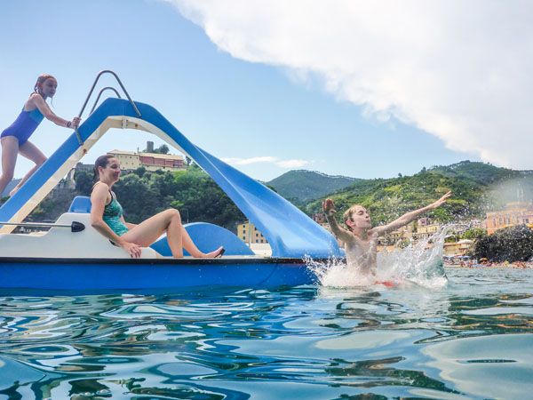 Julie pedals a boat while Tyler and Kara play on the attached slide while in the Cinque Terre, Italy.