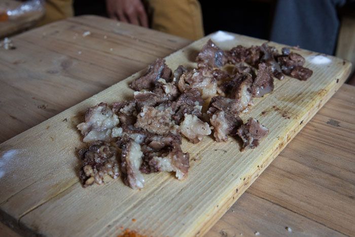 Cow cheeks spread on a wooden slab.