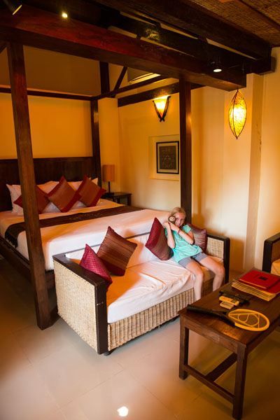 Kara sitting at the end of the bed in a hotel room at the Rikitikitavi hotel in Kampot, Cambodia