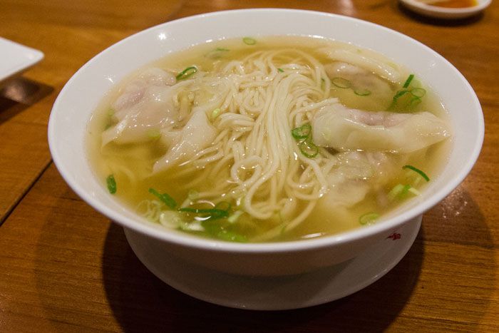 A bowl of Wonton Soup, made from noodles, dumplings, spring onions and chicken soup broth.