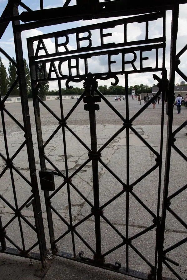 A black-colored door made of iron bars. It reads "Arbeit Macht Frei" (Work sets your free).