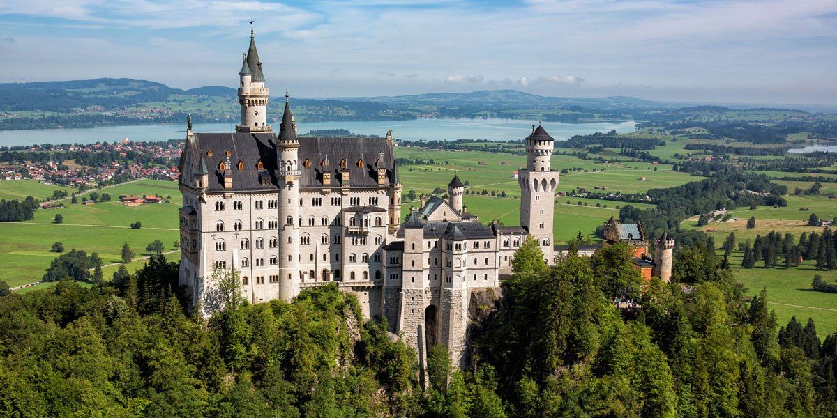 a castle on a hill with Neuschwanstein Castle in the background