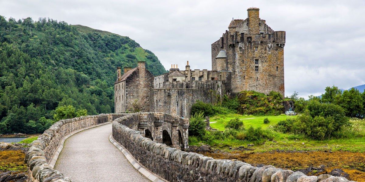 a stone castle with a bridge and a river