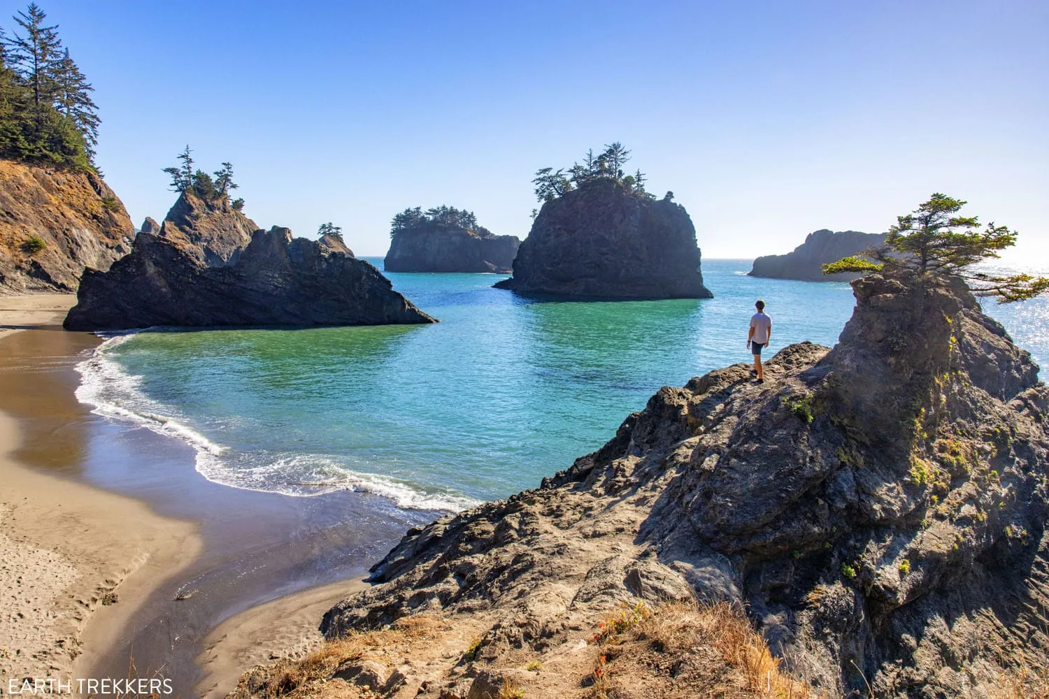 Lone man standing on a large rock overlooking Secret Beach, Oregon